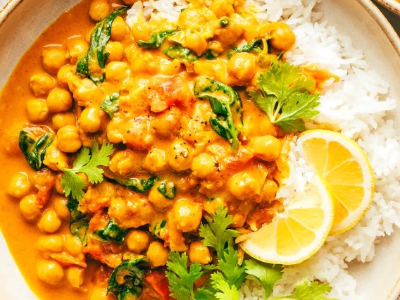Chickpea Curry on a bed of white rice with cilantro and lime as a garnish