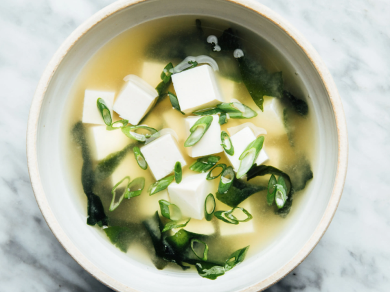 White Bowl with Miso Soup Broth, Green Onions, and Silken Tofu Cubes