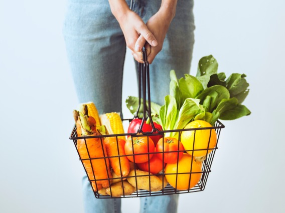 Stutdent holding basket of fruits and vegetables