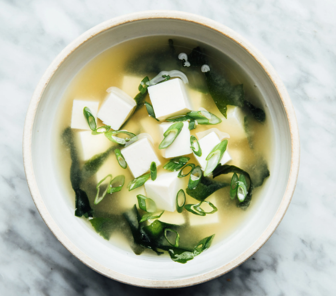 White Bowl with Miso Soup Broth, Green Onions, and Silken Tofu Cubes